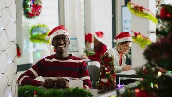 Portrait of african american manager in Christmas decorated office doing vlog for marketing social media channel, talking about company values, trying to recruit new workers video