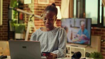 Person shopping online for clothes, copying card information on banking page of website to buy items. African american woman placing order with electronic payment transaction. video