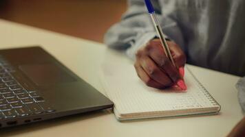 Woman taking handwritten ideas notes at home desk, trying to find perfect work flow and develop online freelancing career. Person using notebook planning for job productivity. Close up. video