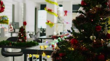 Empty stylishly festive ornate modern office workspace with beautifully decorated Christmas tree. Business charts on computer screen in xmas adorn workplace during winter holiday season video