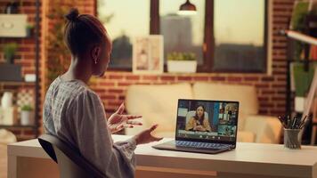 lavoratore chat con clienti su video chiamata, parlando di prezzo elenco e Servizi per costruire in linea carriera nel freelance lavoro. donna utilizzando Teleconferenza a distanza chiamata a casa, tramonto luce.