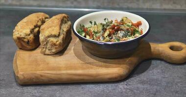 frisch Gemüse Salat und frisch Brot von das Ofen auf ein handgemacht natürlich Kirsche Schneiden Tafel video