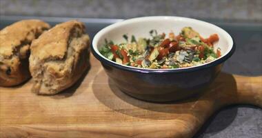 Fresh vegetable salad and homemade fresh bread from the oven on a high cutting board video