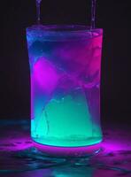 Colorful ice cube splashing into a glass of water in neon light photo