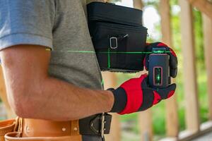Construction Worker with Modern Laser Leveling Tool in His Hands photo