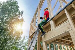 Wooden Skeleton House Frame and the Contractor Worker. photo