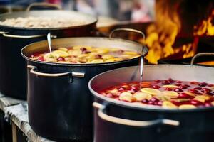 Beverages fruits and berries hot mulled wine in pots with steam in street food market. Generative AI photo