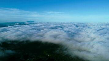 aereo Visualizza al di sopra di il montagne con mare di nebbia durante mattina Alba nel blu cielo. mare di nuvole in giro montagna picchi a Alba. nascosto viaggio nel settentrionale Tailandia video