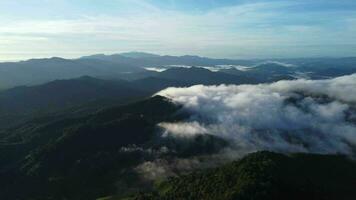 Aerial view over the mountains with sea of fog during morning sunrise in blue sky. Sea of clouds around mountain peaks at sunrise. Unseen travel in Northern Thailand video