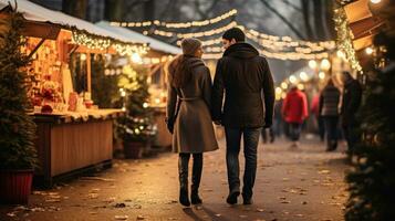 Couple enjoying Christmas market walking near stalls photo