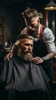 A barber trimming a man's beard with clippers photo