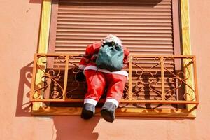a santa claus statue hanging from a balcony photo