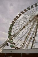 un ferris rueda es mostrado en contra un nublado cielo foto