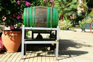 a wooden barrel with green trim sitting on a sidewalk photo