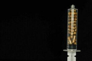 a syringe filled with pills photo