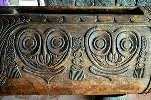 a carved wooden box with faces on it photo