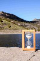 An hourglass on a rock photo