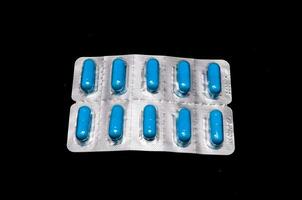 Blue pills isolated on black background photo
