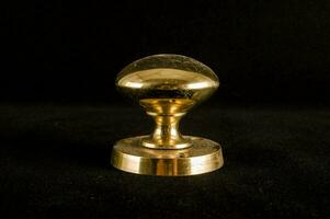 a brass knob on a black background photo