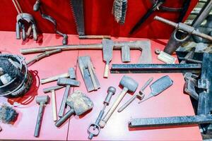 a display of old tools on a red table photo