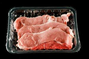 Meat in a container on black background photo