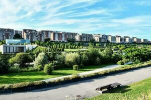 a park with a bench in front of buildings photo