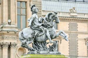 a statue of a man on a horse in front of a building photo