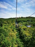 Photo of a ski lift ride over a beautiful green hillside