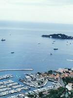 Photo of a bustling harbor filled with boats on a serene body of water