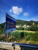 Photo of a blue road sign on the side of a highway