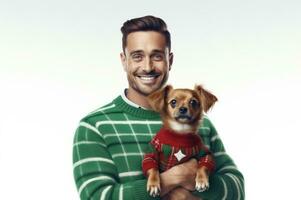 White man in warm cozy green sweater hugging his pet purebred pomeranian chihuahua dog dressed in Christmas sweater. Joyfully smiling. Merry Christmas. Happy New Year. white background. AI generated photo