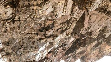 Buddha image on  rock over Kar Gah river, Gilgit-Baltistan, Pakistan.A closeup shot of a mountain rock that's perfect for a background.texture of granite rock,Seamless rock,rock in  green environment photo