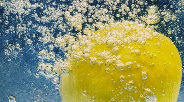 Underwater lemon slice in soda water or lemonade with bubbles. photo