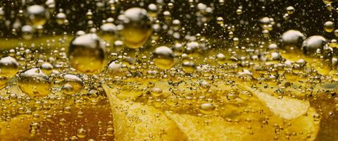 Deep fried potato chips under golden oil water. photo