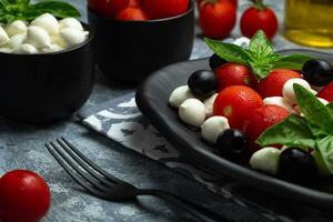 clásico italiano ensalada caprese servido en original formar con Cereza Tomates, mini mozarella perlas, albahaca hojas y balsámico vidriar foto