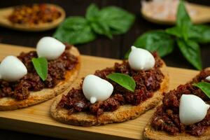 Bruschetta with dried tomatoes, mozzarella, garlic and olive oil. Traditional Italian cuisine sandwich made of grilled ciabatta. Antipasti photo