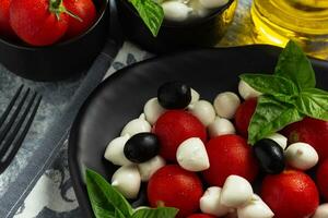 clásico italiano ensalada caprese servido en original formar con Cereza Tomates, mini mozarella perlas, albahaca hojas y balsámico vidriar foto