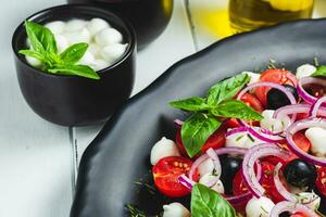 cerca arriba de un delicioso italiano caprese ensalada con Tomates, queso Mozzarella y albahaca foto