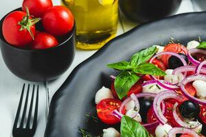 cerca arriba de un delicioso italiano caprese ensalada con Tomates, queso Mozzarella y albahaca foto