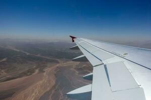 ver a el alas desde un avión durante un vuelo terminado el Desierto en Egipto con cielo foto