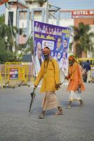 sadhu en tradicional naranja ropa caminando abajo un la carretera mucho, madhya pradesh, India septiembre 04,2023 foto