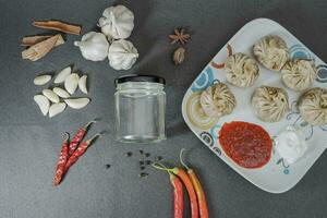 Variety Nepalese traditional dumpling momos served with tomato ketchup and fresh lemon photo