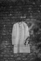 Indian groom wedding sherwani hanging on frame photo