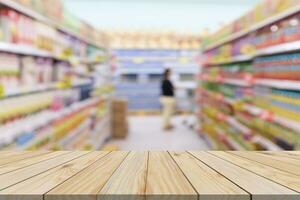 Empty wood table top with supermarket blurred background for product display photo