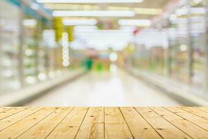 Empty wood table top with supermarket blurred background for product display photo