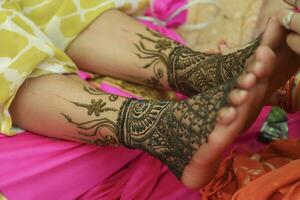 Indian bride showing feet mehndi design her wedding ceremony photo