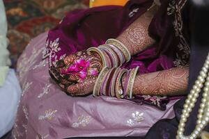 Bride holding flower, Indian wedding ceremony photo