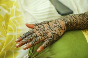 An Indian bride showing her hand's mehndi tattoos design photo