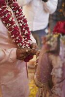 Indian groom putting ring on Indian bride photo