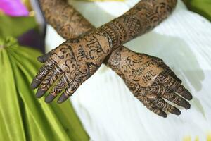 An Indian bride showing her hand's mehndi tattoos design photo